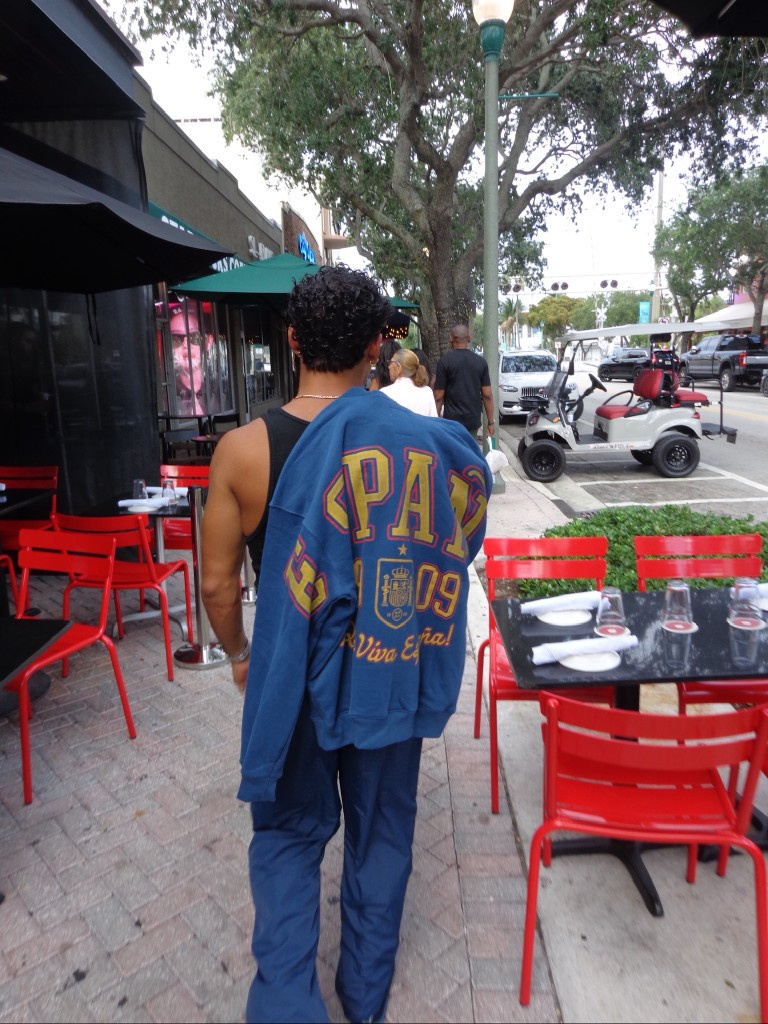 Man on a street with a blue PAU varsity sweater over his shoulder