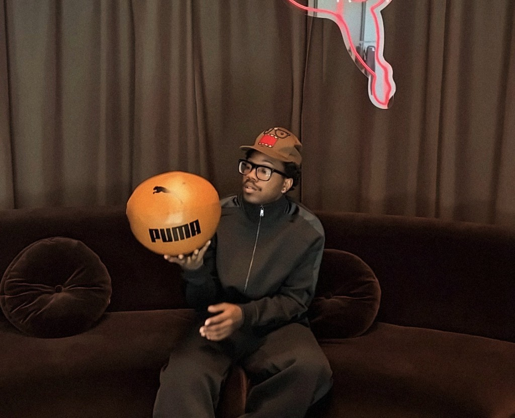 Creator on a couch with a Puma basketball and neon sign